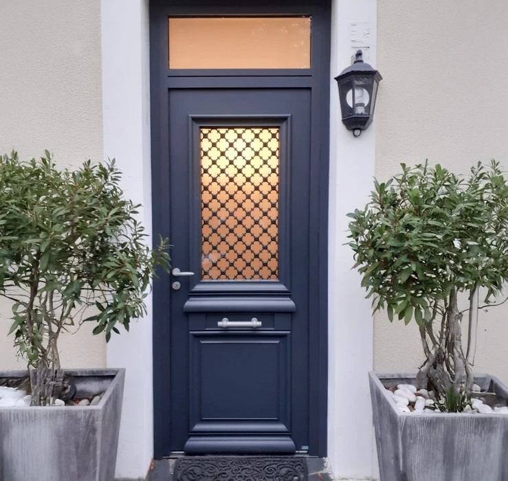 Entrée résidentielle extérieure avec porte d'entrée bleue marine à panneau vitré décoratif motif géométrique doré