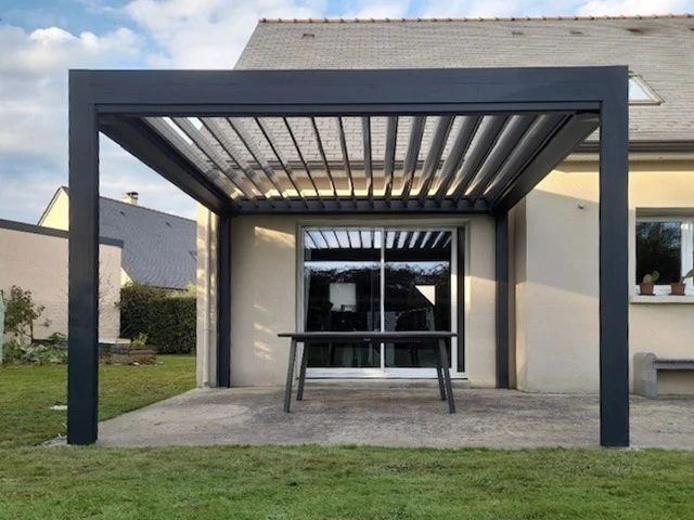 Terrasse extérieure résidentielle avec pergola bioclimatique moderne à lames orientables
