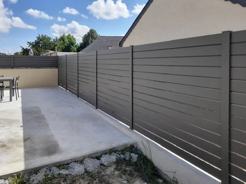 Terrasse extérieure résidentielle avec clôture moderne en lames horizontales grises