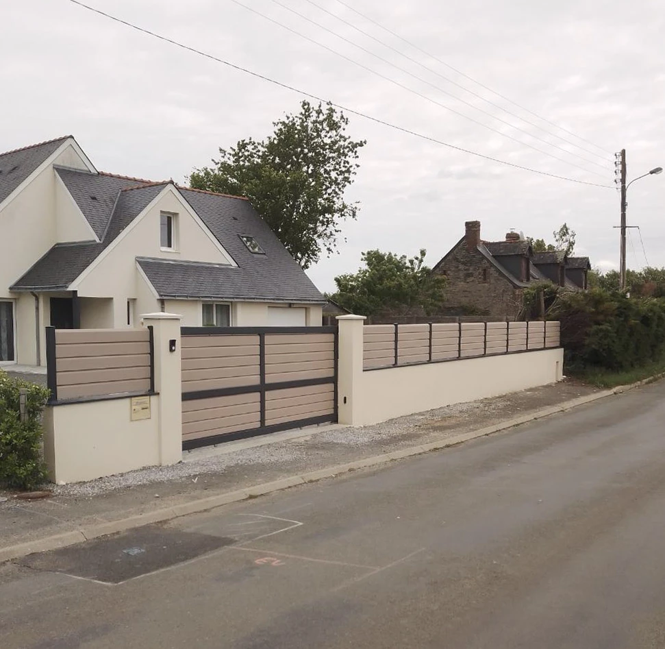 Propriété résidentielle avec clôture moderne composée de panneaux horizontaux en composite bois-aluminium sur muret béton blanc