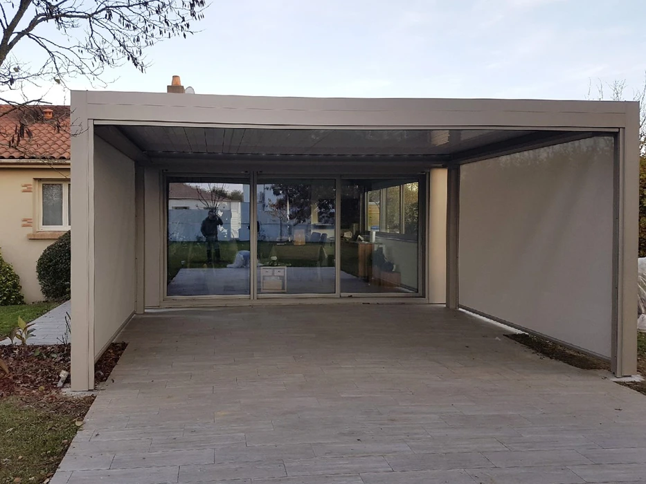 Extérieur résidentiel montrant une porte de garage sectionnelle moderne gris anthracite avec quatre hublots circulaires alignés dans le panneau supérieur