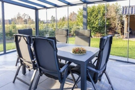 Porte de garage sectionnelle rouge bordeaux avec quatre hublots losangés en verre fumé encadrés de blanc, équipée d'une poignée métallique