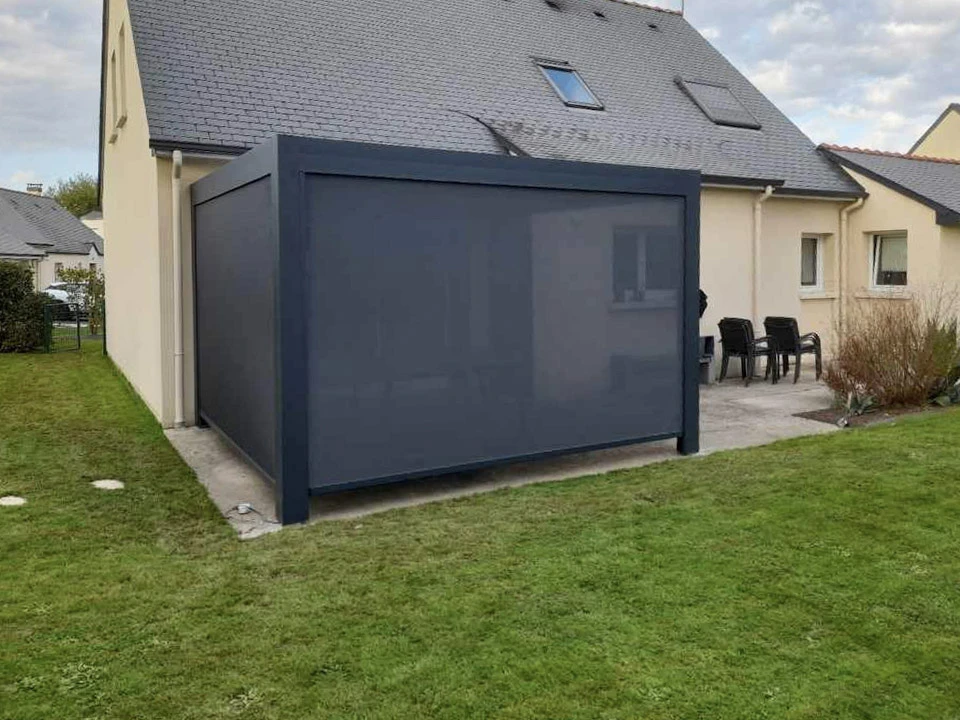 Extérieur résidentiel montrant une porte de garage sectionnelle moderne gris anthracite avec quatre hublots circulaires alignés dans le panneau supérieur