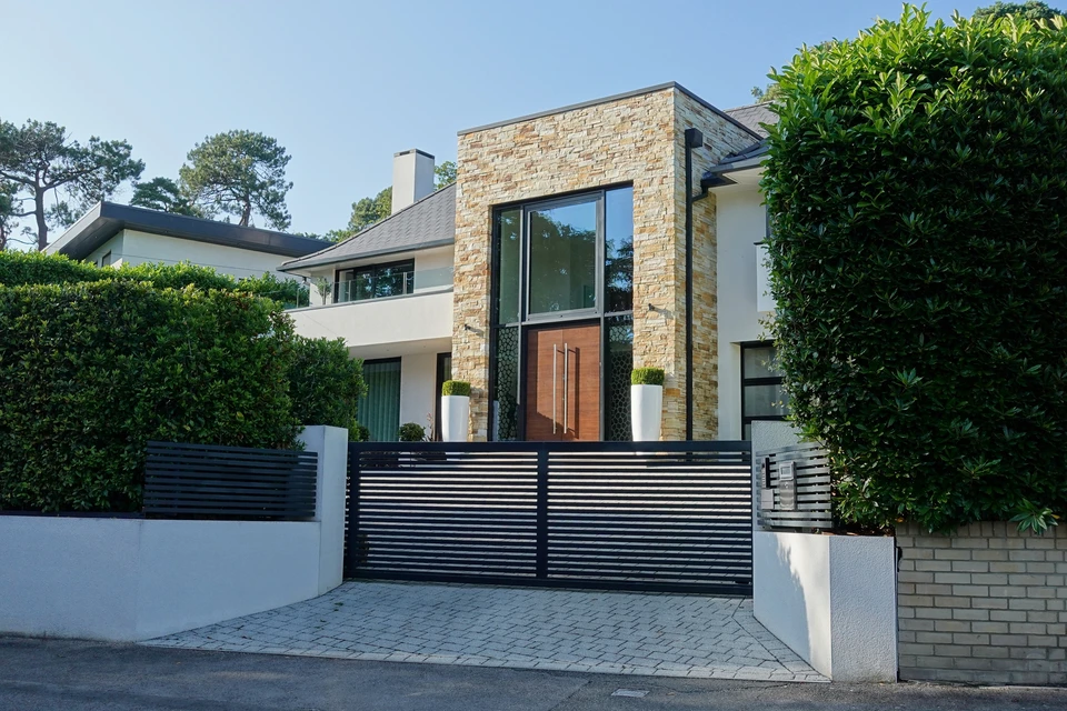 Entrée d'immeuble moderne avec interphone vidéo intégré dans un mur en béton apparent