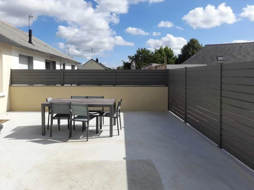 Façade extérieure d'une maison avec fenêtre à battants blancs ouverts flanquée de volets battants blancs à lames diagonales